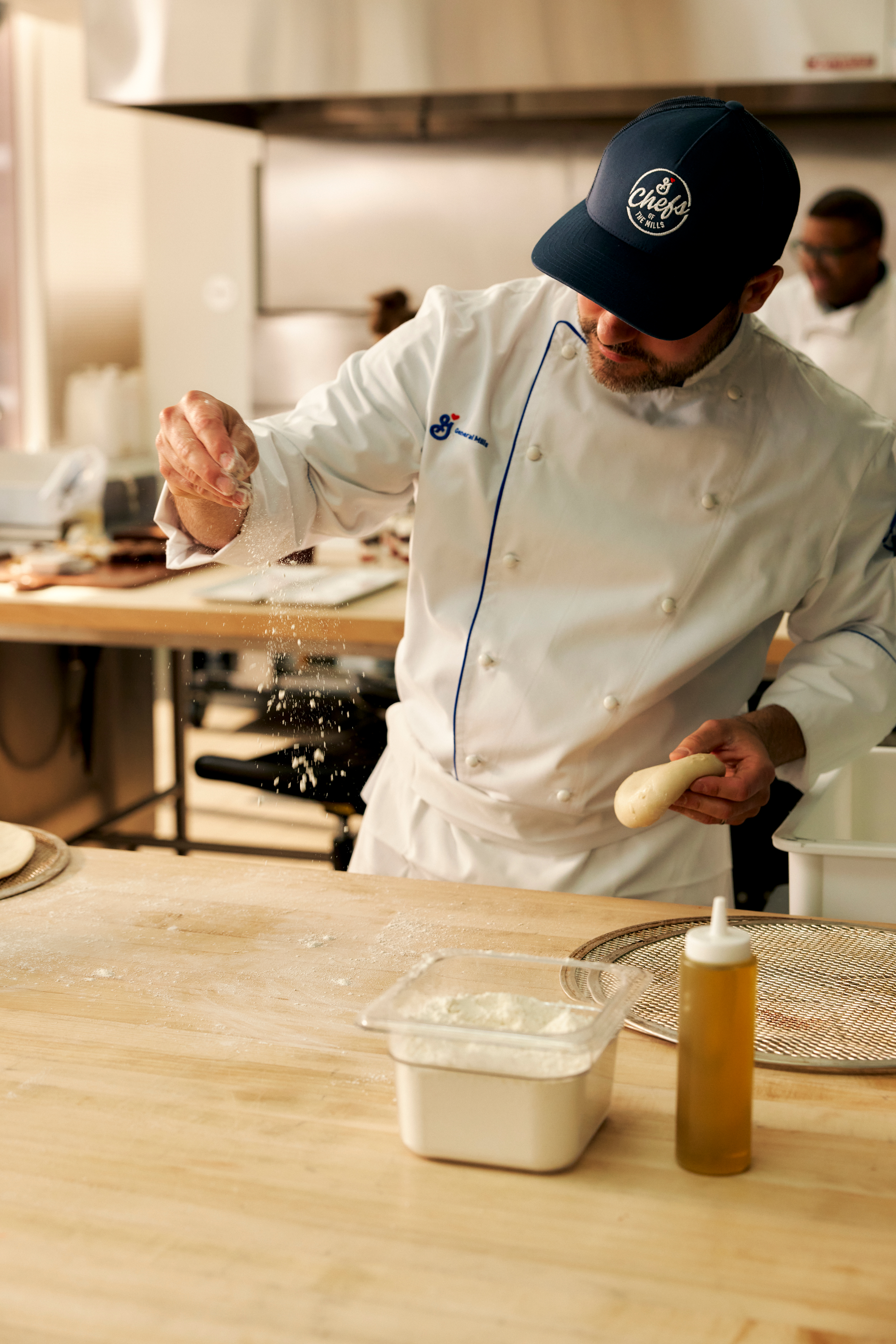 Chef sprinkling dough on a work surface